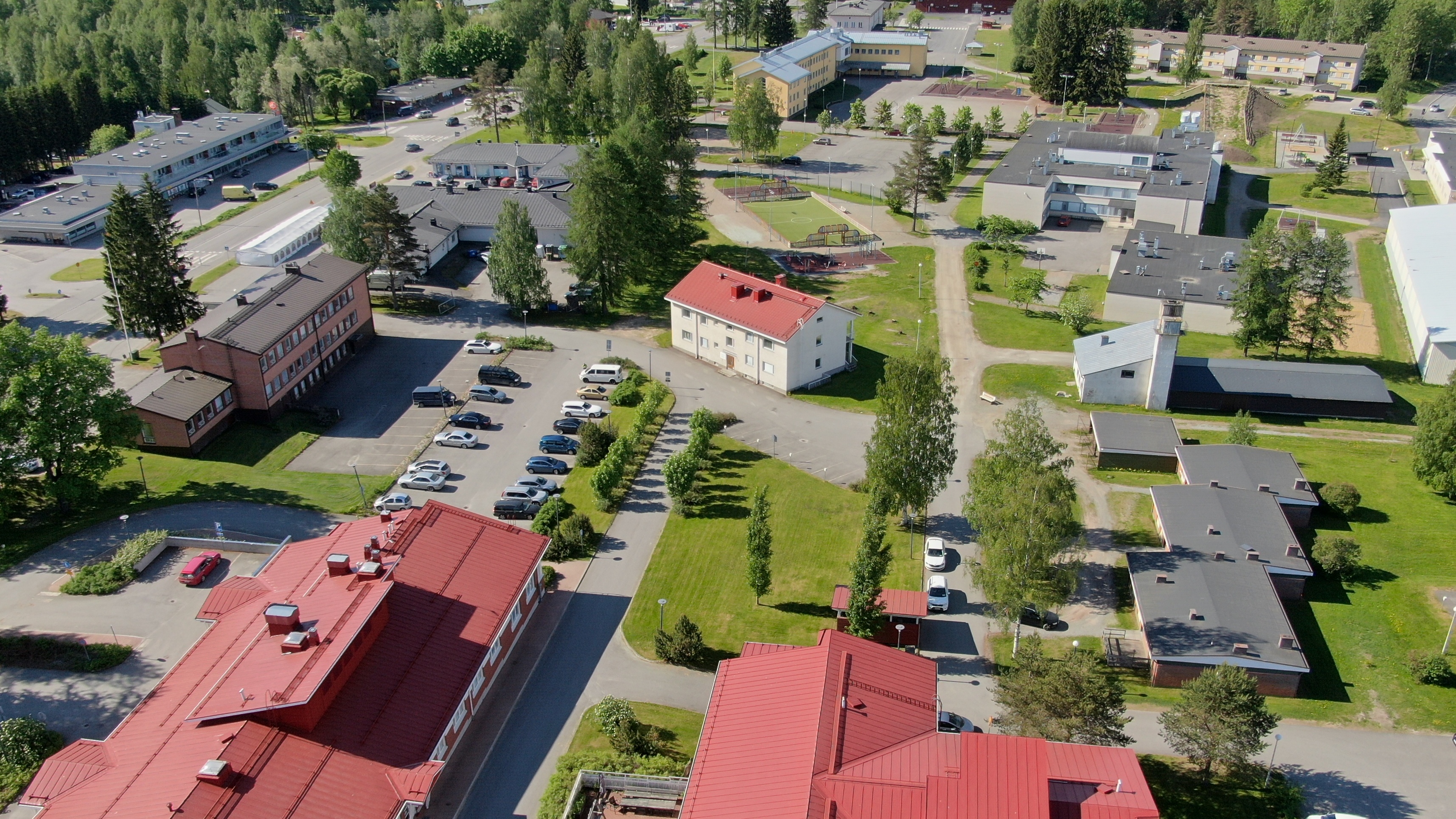 Polvijärven keskusta-aluetta, jossa näkyy Y-kortteli, vanha kunnantalo ja muita kunnanvirastorakennuksia, koulu sekä parkkipaikka. Kuvassa olevalle alueelle rakennetaan 60-paikkainen asumispalveluyksikkö.